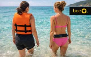 due donne entrano in mare una con giubbotto salvagente e una con cintura autogonfiabile discreta indossata in vita